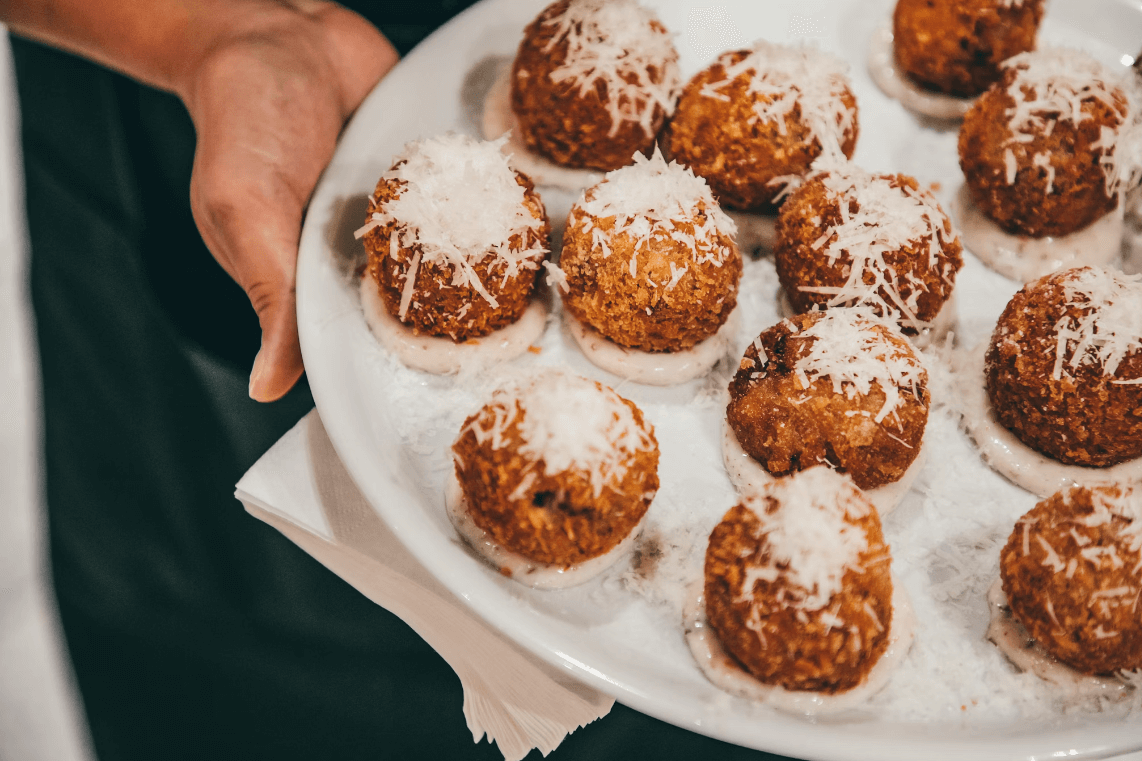 At Home with Angela Gray -Tray of arancini, with parmesan shavings on top being presented to camera