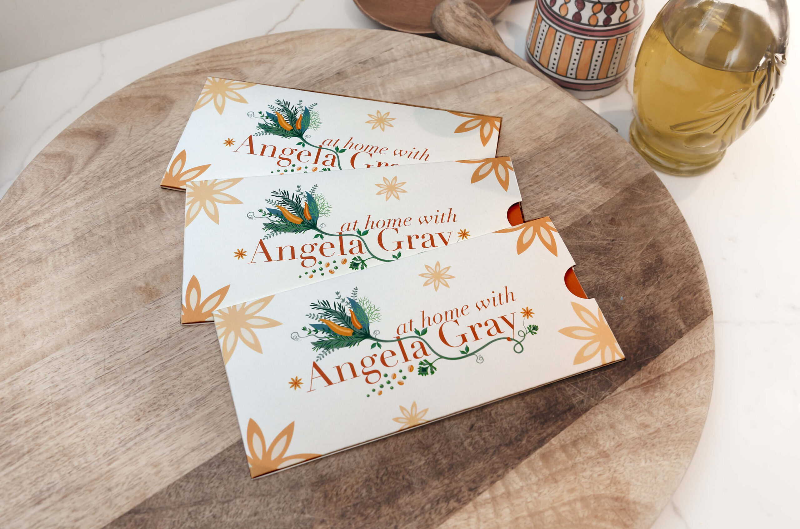 At Home with Angela Gray Giftcard - giftcards in decorative sleeve laid out on a wooden table